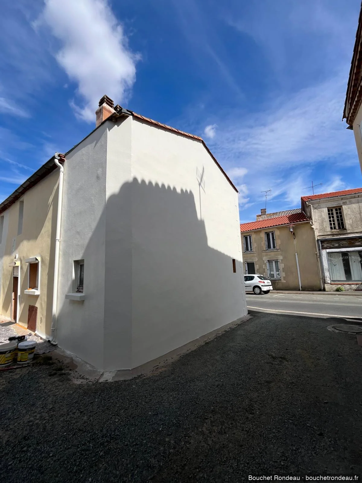 Vue longue après ravalement, pignon aveugle rénové en centre bourg vendéen à Chantonnay